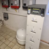 Batteriespeicher rechts und Wechselrichter an der Wand